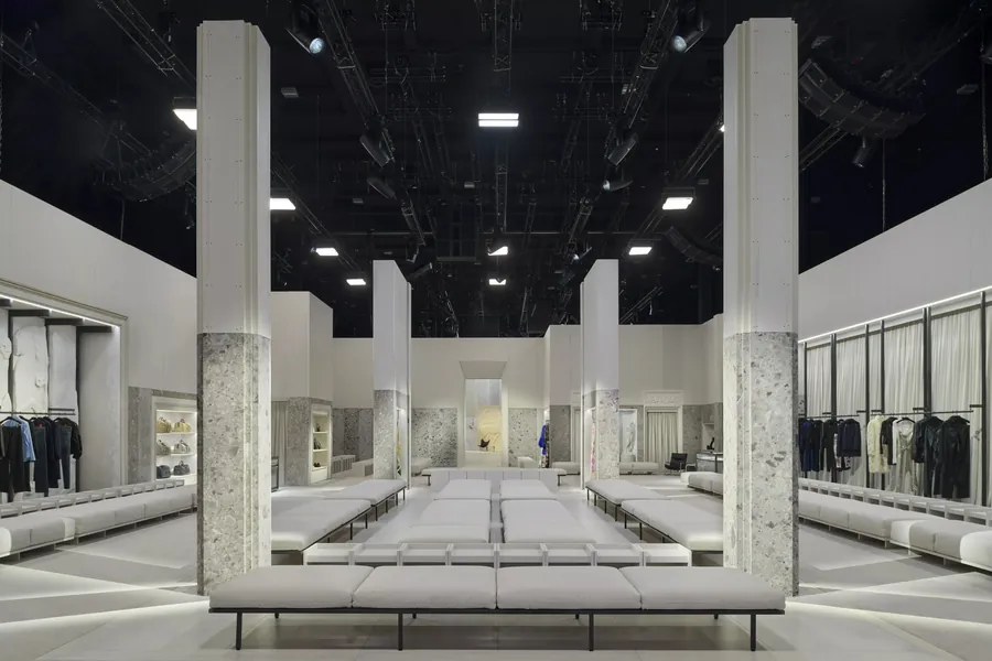 Gucci The Store Show: the show space designed as a store, with pale benches, stone columns and clothing rails